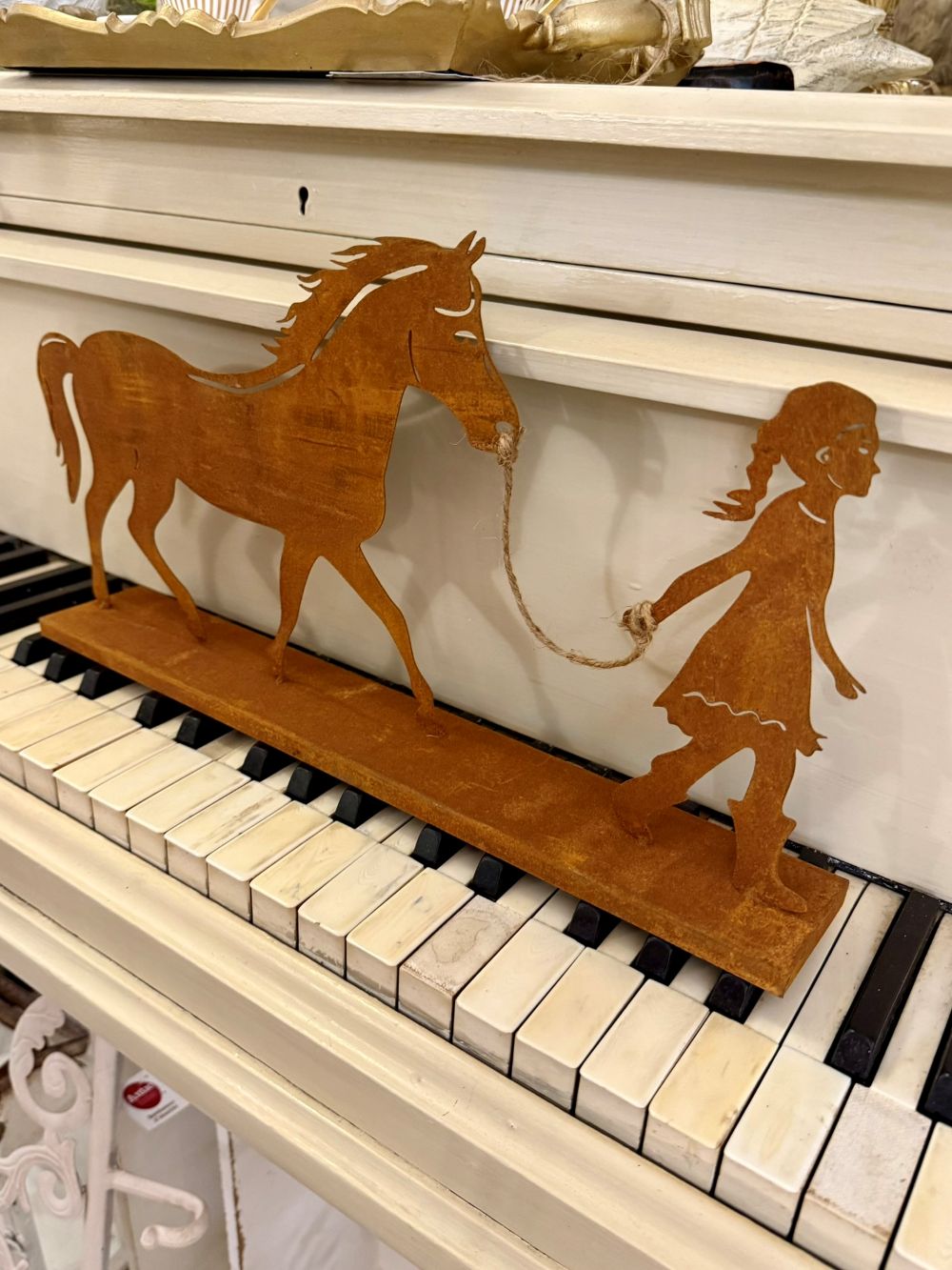 Silhouette décorative en métal rouillé représentant une fillette tenant un cheval, style shabby chic et poétique, pour déco intérieure ou jardin champêtre