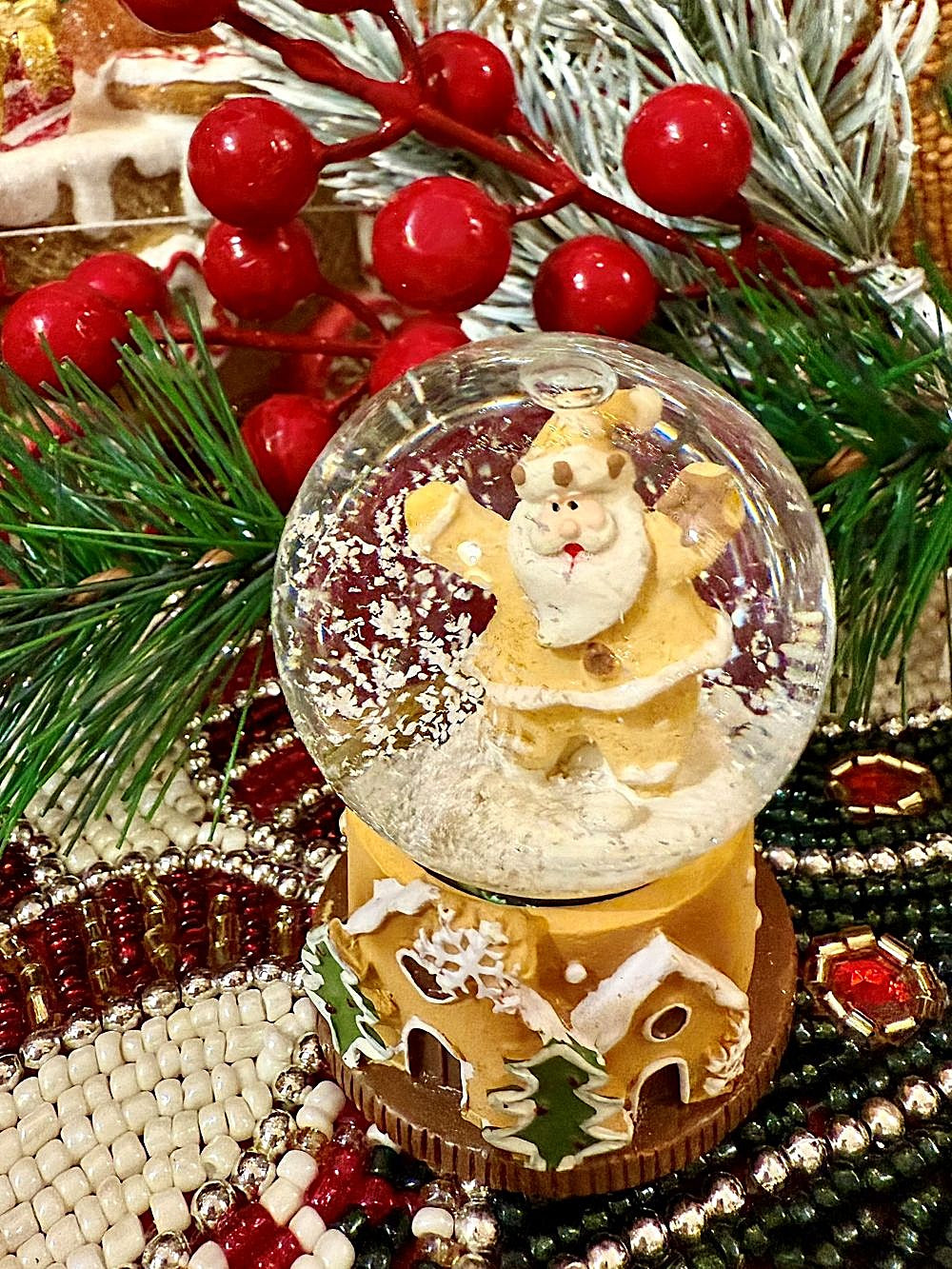 Boule à neige miniature avec Père Noël doré et base en forme de maison pain d’épices, déco de Noël romantique et féérique aux tons dorés, blancs et verts