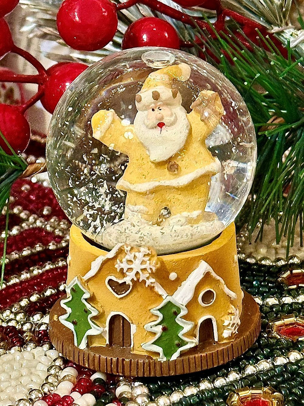 Boule à neige miniature avec Père Noël doré et base en forme de maison pain d’épices, déco de Noël romantique et féérique aux tons dorés, blancs et verts
