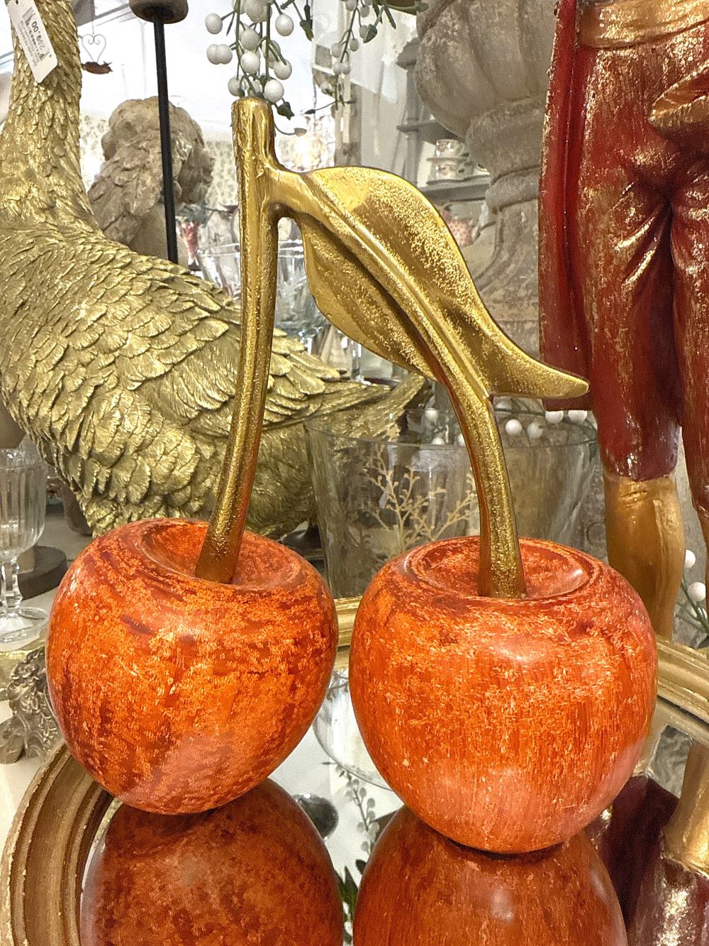 Décoration en forme de cerises rouges avec feuille dorée, style romantique et charme, couleurs rouge cuivré et or, ambiance élégante et poétique