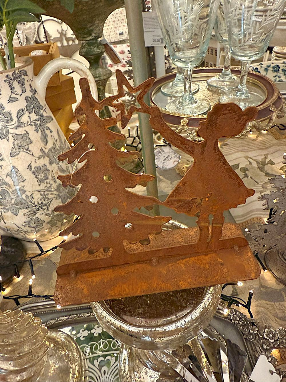 Décoration de Noël en métal rouillé représentant une petite fille plaçant une étoile sur un sapin, tons brun cuivre, style shabby chic et ambiance féérique