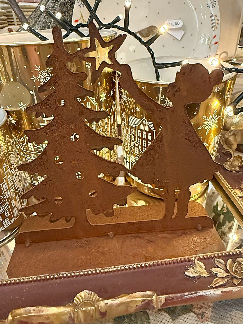 Décoration de Noël en métal rouillé représentant une petite fille plaçant une étoile sur un sapin, tons brun cuivre, style shabby chic et ambiance féérique