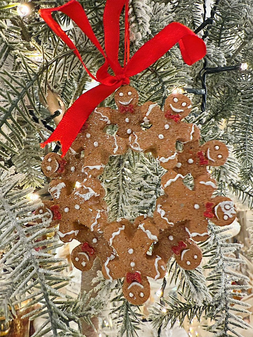 Décoration de sapin à suspendre en forme de couronne de petits bonshommes pain d’épices avec ruban rouge, style shabby chic et féérique, tons brun, blanc et rouge
