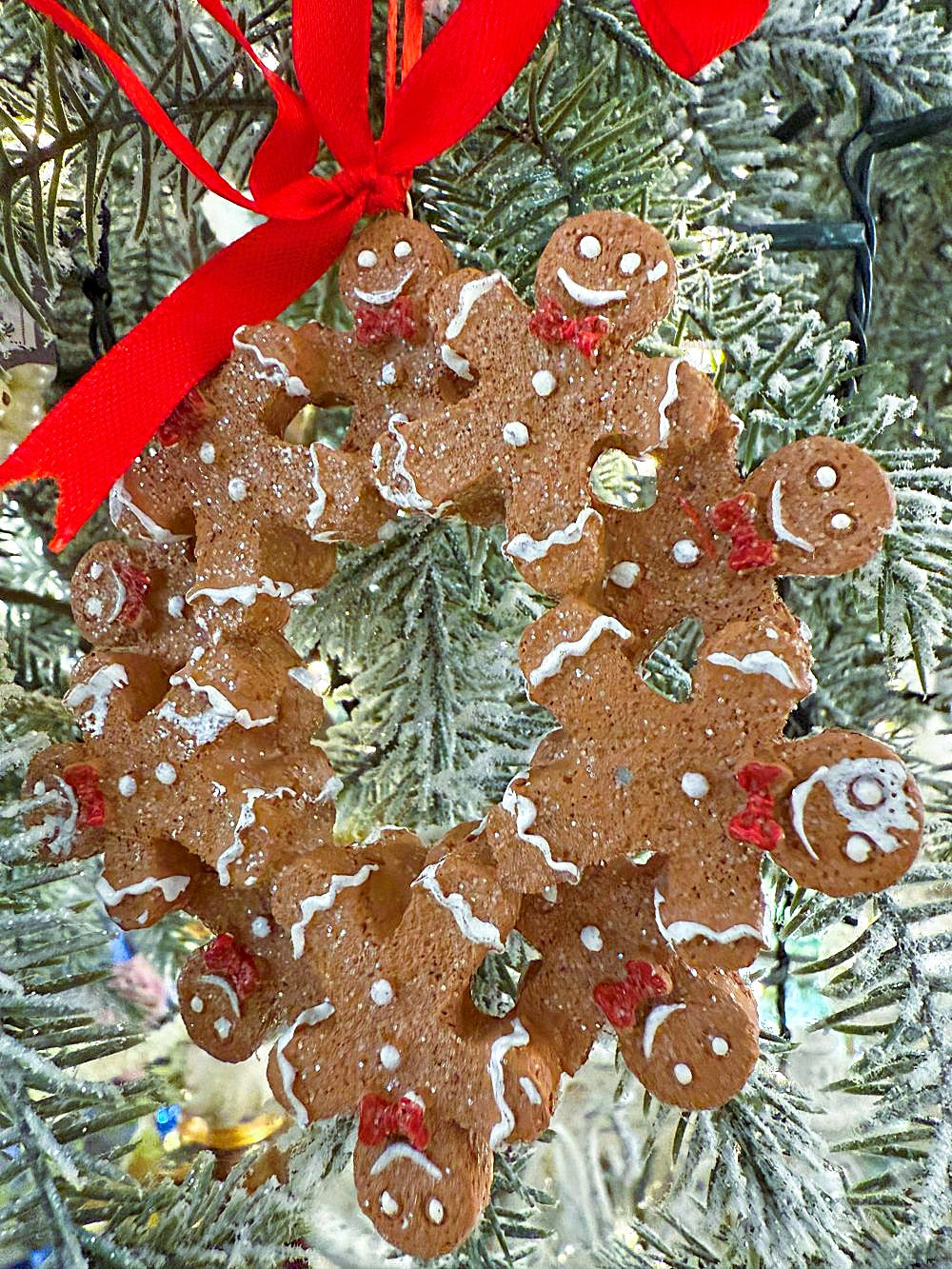 Décoration de sapin à suspendre en forme de couronne de petits bonshommes pain d’épices avec ruban rouge, style shabby chic et féérique, tons brun, blanc et rouge