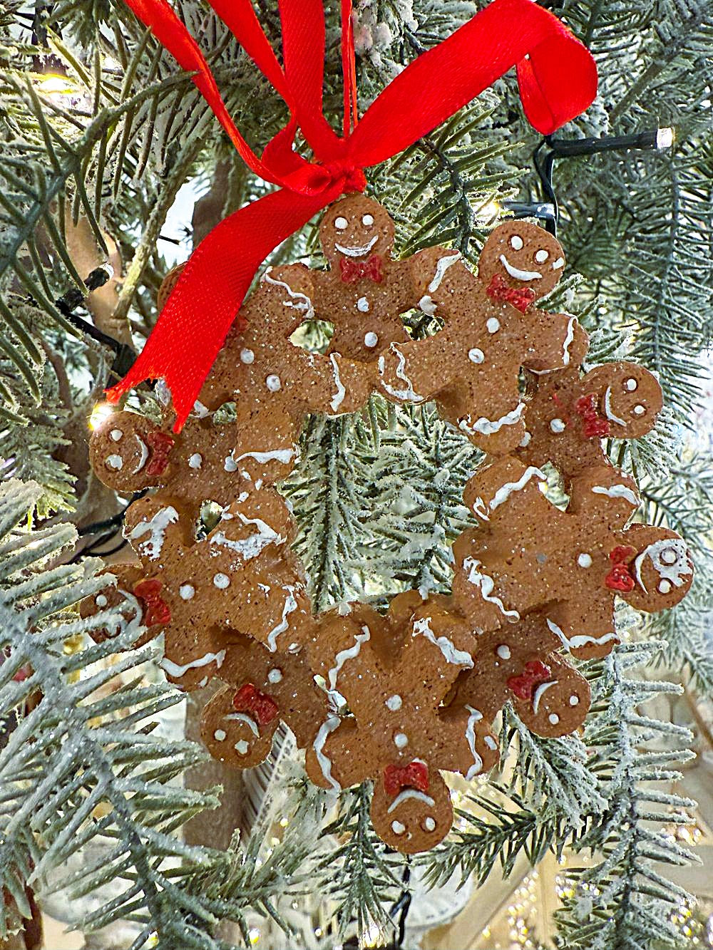 Décoration de sapin à suspendre en forme de couronne de petits bonshommes pain d’épices avec ruban rouge, style shabby chic et féérique, tons brun, blanc et rouge