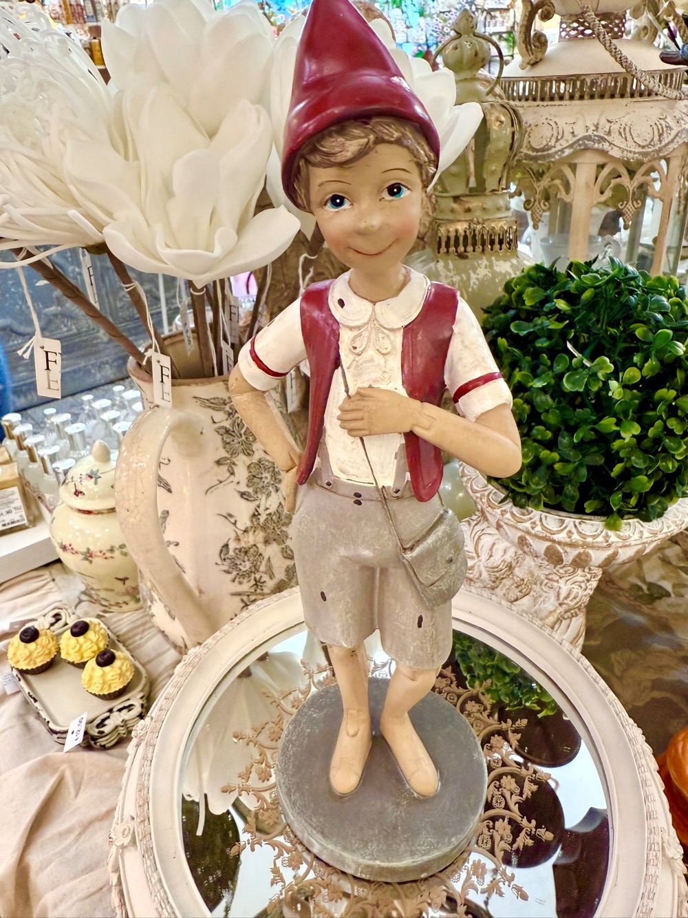 Figurine déco de Pinocchio en posture de marche, couleurs rouge bordeaux, beige et gris clair, style poétique et shabby chic, compagnon de balade au charme romantique