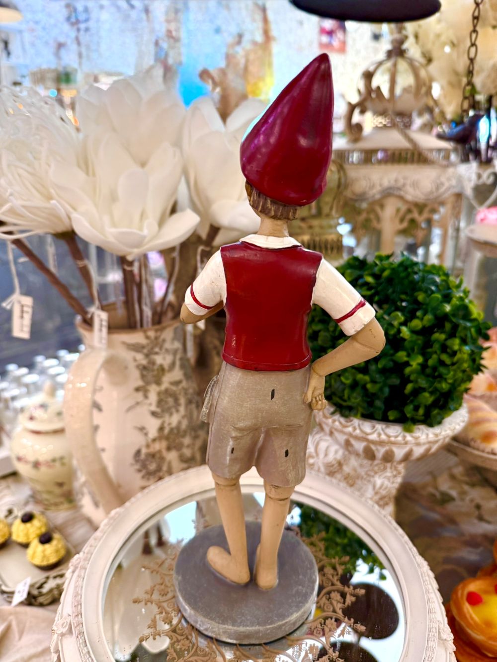 Figurine déco de Pinocchio en posture de marche, couleurs rouge bordeaux, beige et gris clair, style poétique et shabby chic, compagnon de balade au charme romantique