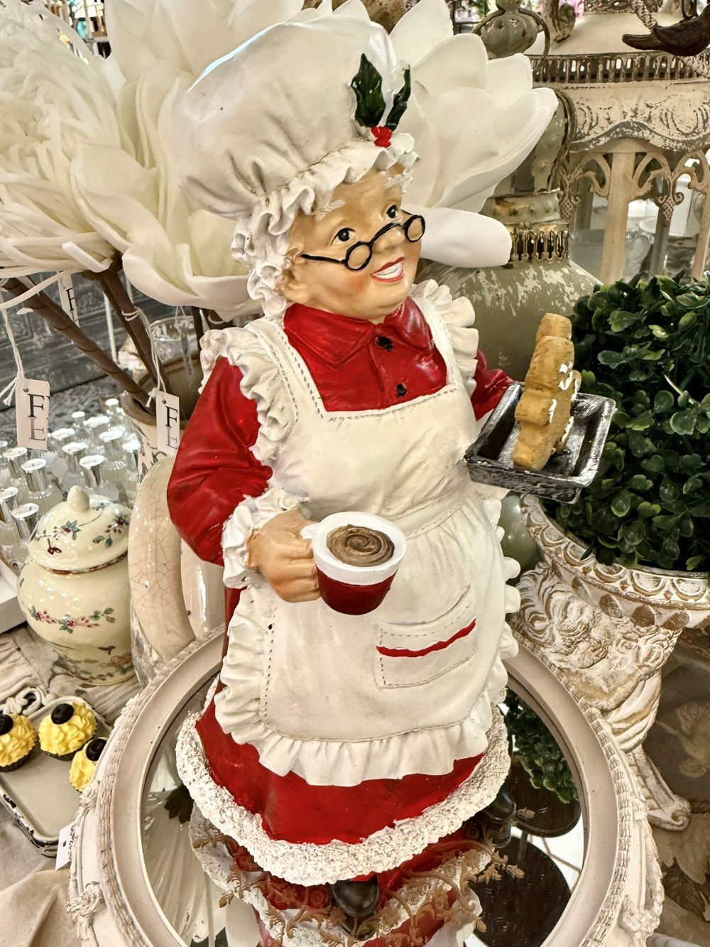 Figurine décorative de 30 cm représentant la Mère Noël en tenue de pâtissière rouge et blanche, tenant une tasse et un biscuit pain d’épices, style vintage et féérique
