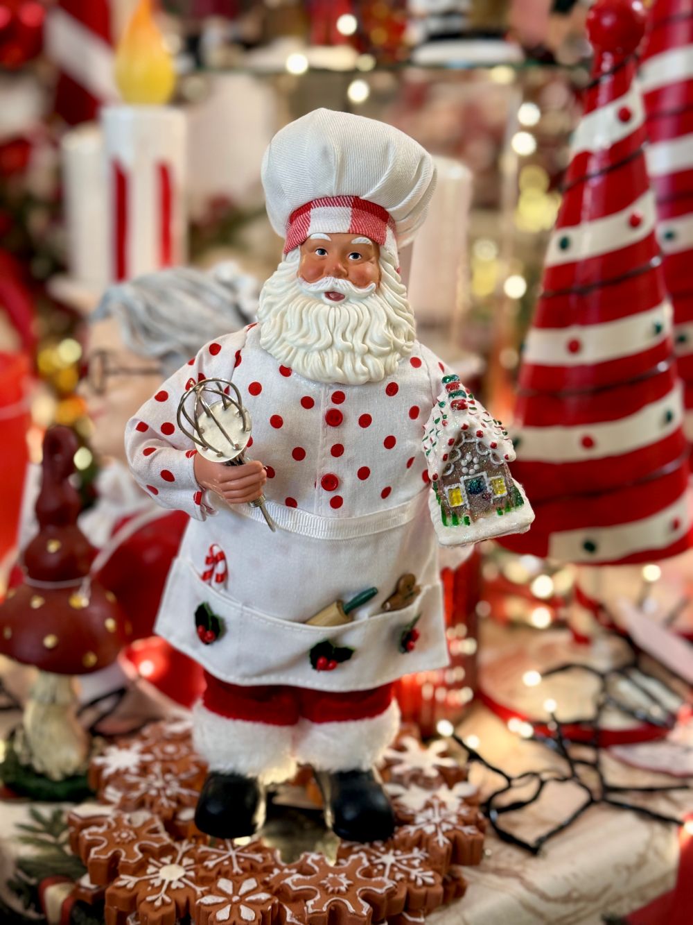 Figurine Père Noël Pâtissier 28 cm en rouge et blanc, tenant un fouet et une maison en pain d’épices, style shabby chic et féérique pour décoration de Noël