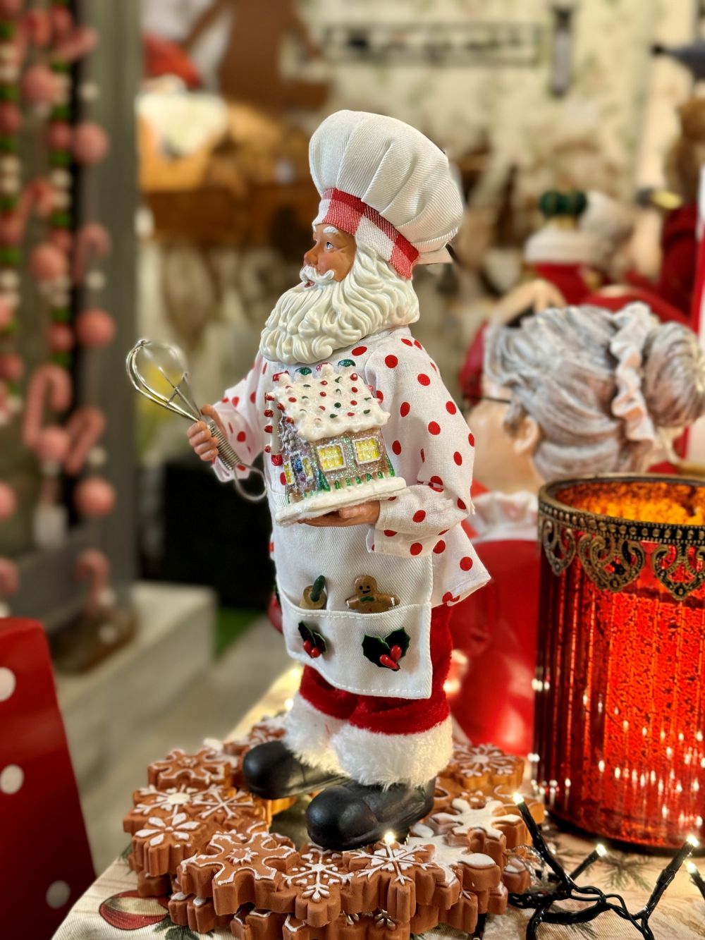 Figurine Père Noël Pâtissier 28 cm en rouge et blanc, tenant un fouet et une maison en pain d’épices, style shabby chic et féérique pour décoration de Noël