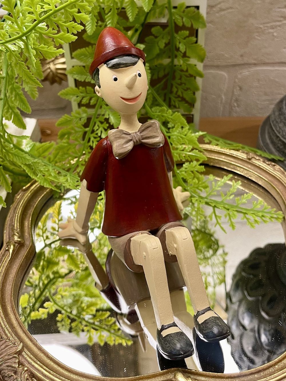 Figurine Pinocchio assis rouge beige marron style décoration romantique et vintage