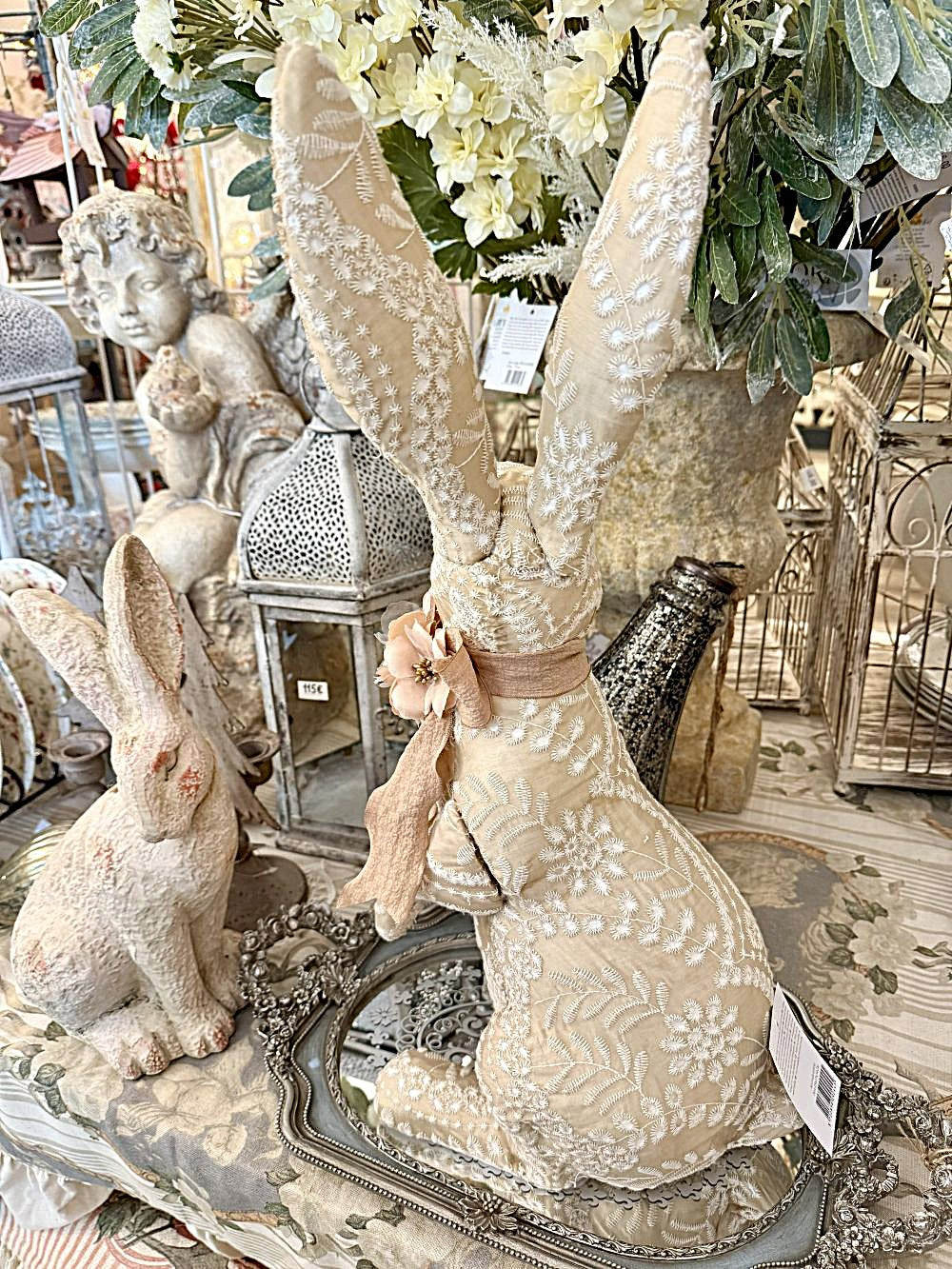 Lapin décoratif en tissu brodé beige et blanc avec fleur rose, style shabby chic et romantique, idéal pour une décoration poétique et féérique.