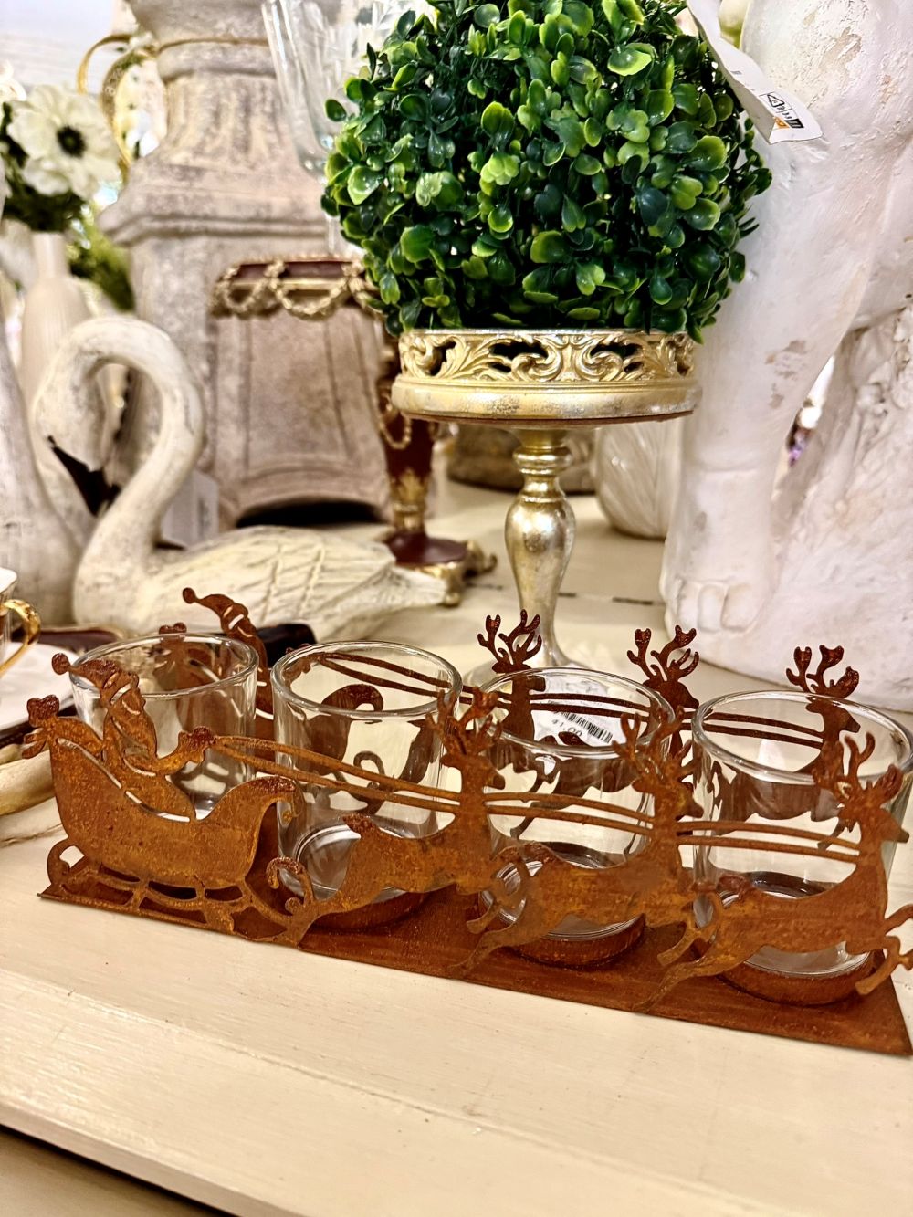 Photophore de Noël en métal rouille représentant un traîneau du Père Noël tiré par des rennes, avec 4 emplacements pour bougies chauffe-plat, style romantique et féérique