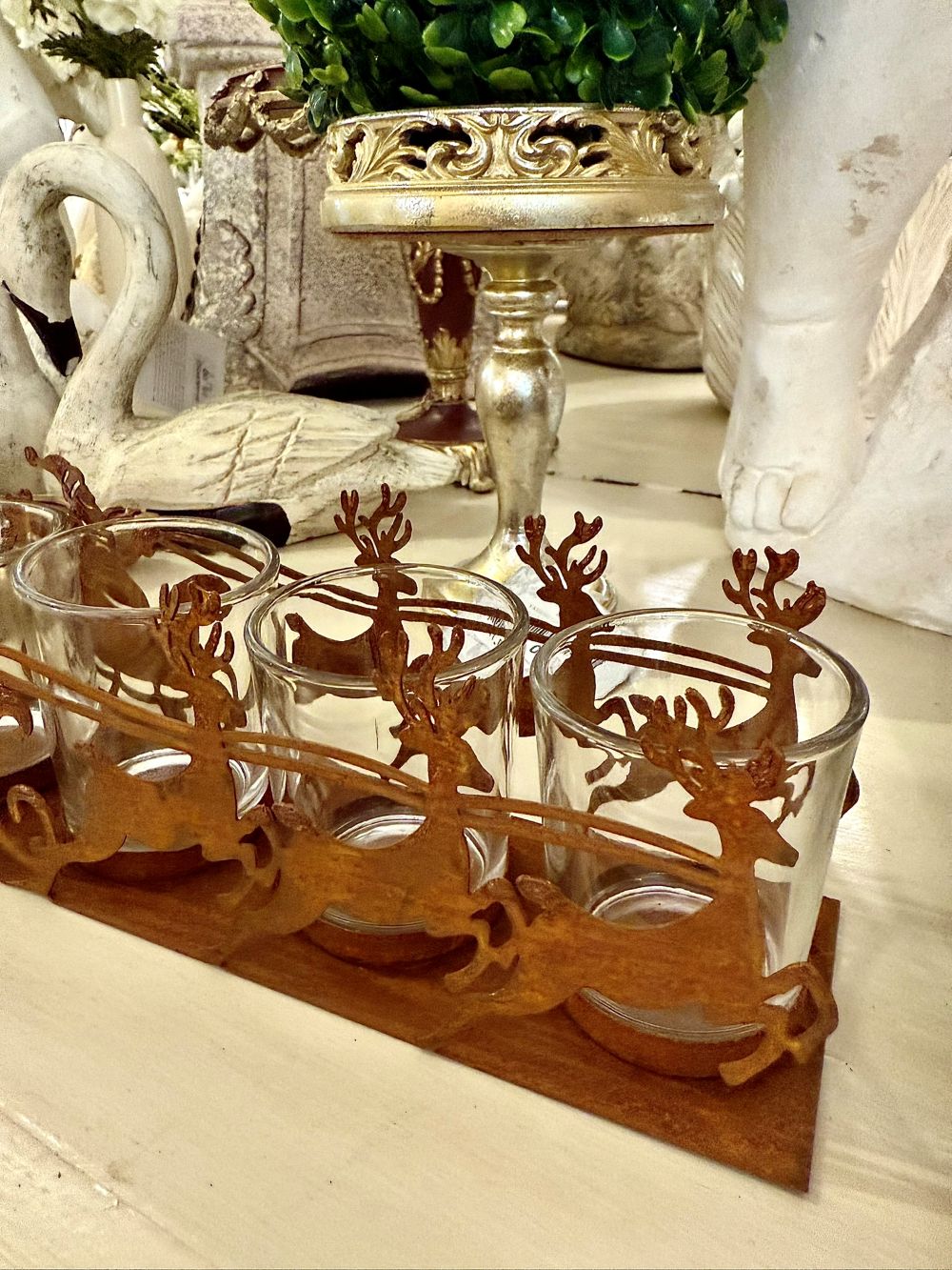 Photophore de Noël en métal rouille représentant un traîneau du Père Noël tiré par des rennes, avec 4 emplacements pour bougies chauffe-plat, style romantique et féérique