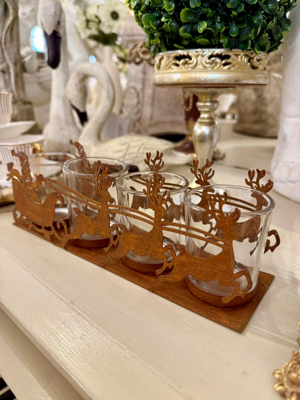 Photophore de Noël en métal rouille représentant un traîneau du Père Noël tiré par des rennes, avec 4 emplacements pour bougies chauffe-plat, style romantique et féérique