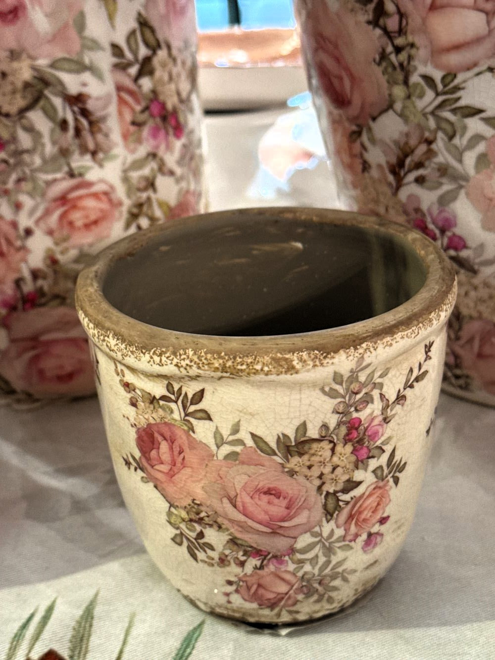 Pot décoratif en céramique style shabby chic avec motif de roses anglaises dans les tons crème, rose poudré et vert, pour une ambiance romantique et poétique