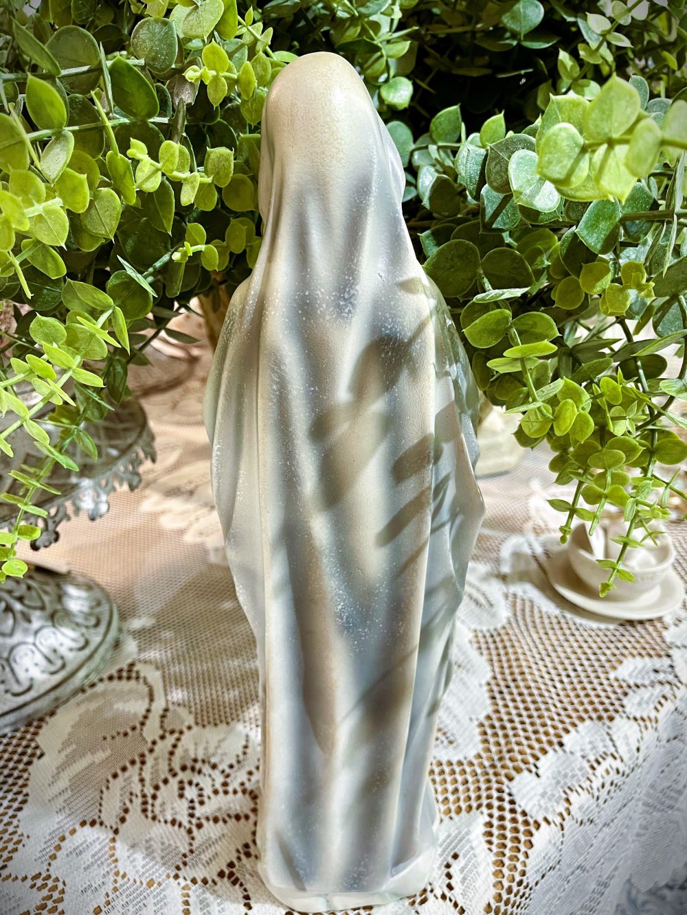 Statuette décorative de la Vierge Marie en prière tenant un chapelet doré, finitions nacrées blanc cassé, détails roses à la base, style romantique et shabby chic, ambiance spirituelle et poétique