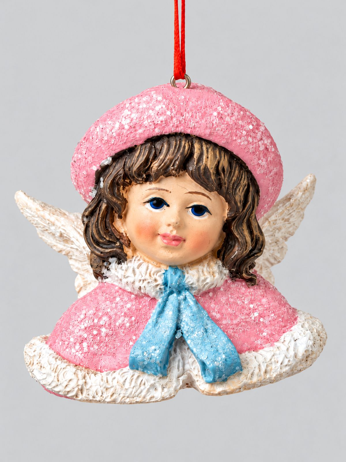 Figurine Ange Poupée Victorienne à suspendre, bonnet et cape roses pailletés, ruban bleu et ailes blanches, sur fond gris clair.