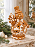 Bonhomme de neige Biscuit sur une console ivoire patinée, près de branches de sapin et de boules nacrées.