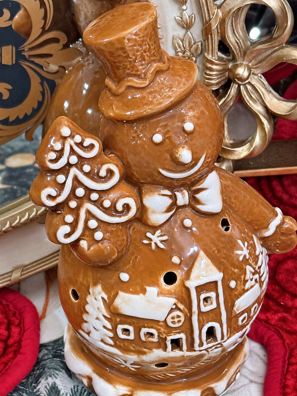 Vue rapprochée du bonhomme de neige Biscuit montrant son chapeau, son sapin et son village enneigé en relief.