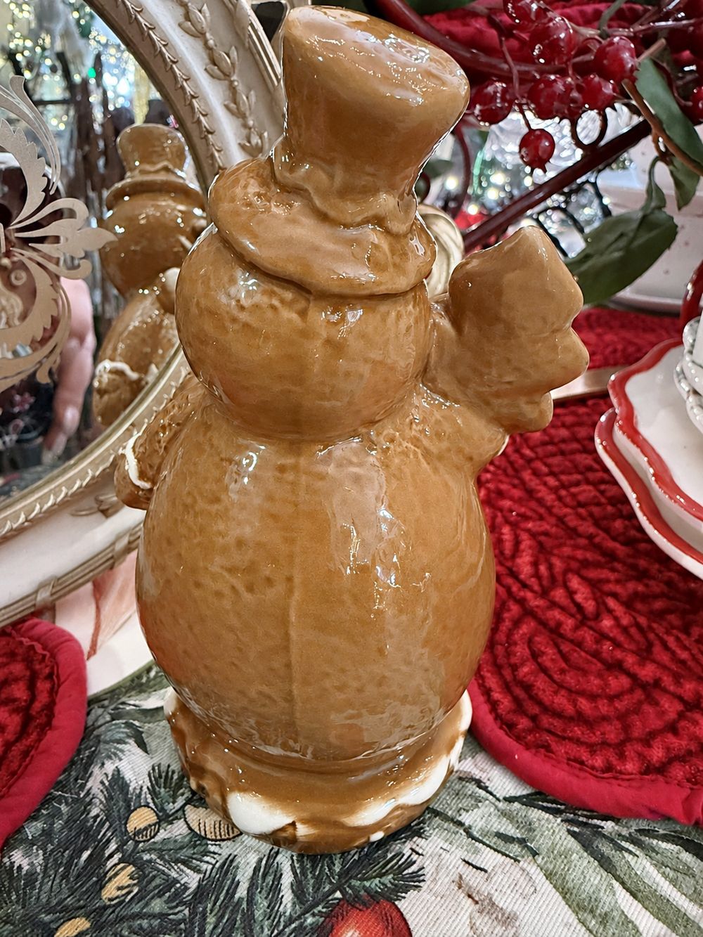 Vue de dos du bonhomme de neige Biscuit montrant sa porcelaine vernissée caramel et son socle blanc.