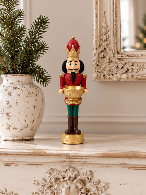 Bougeoir Casse-Noisette Royal sur une console patinée, près d’un vase de sapin et d’un miroir ancien.