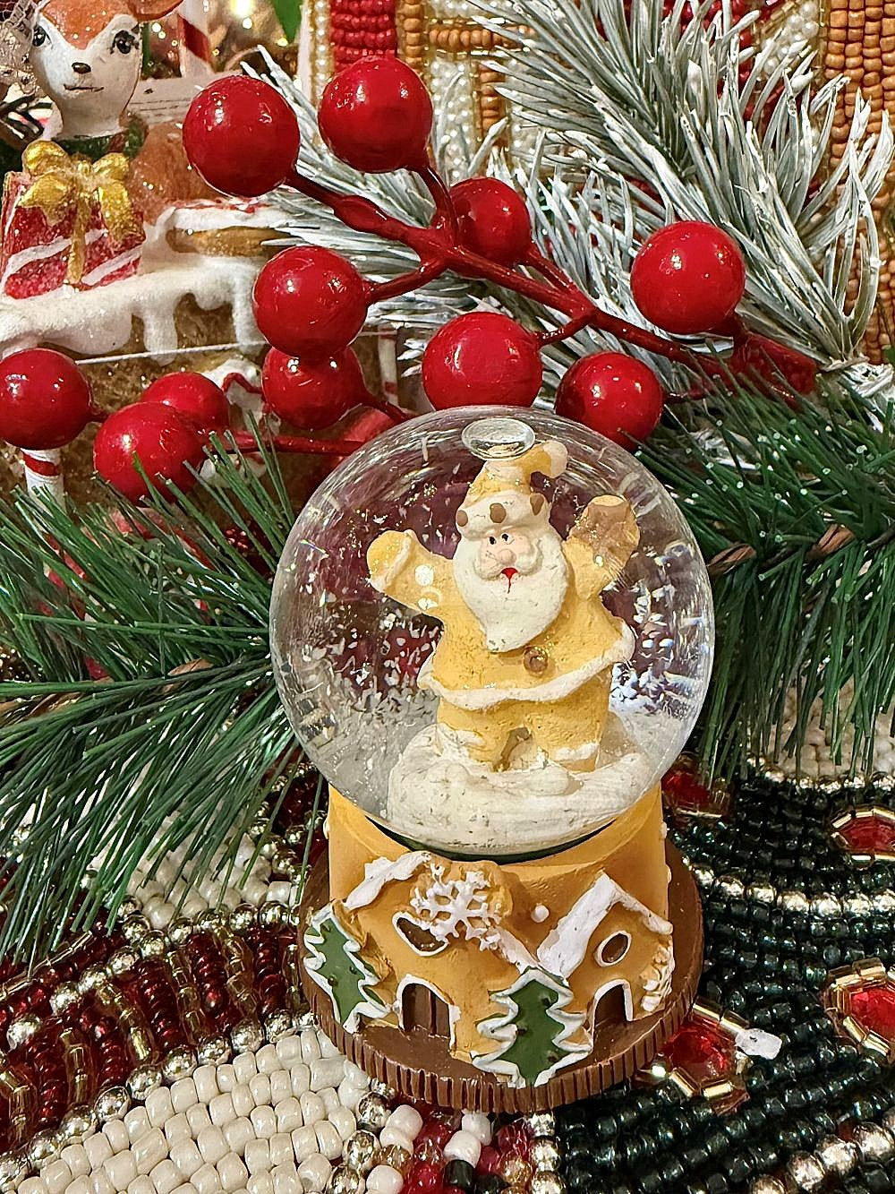 Boule à neige miniature avec Père Noël doré et base en forme de maison pain d’épices, déco de Noël romantique et féérique aux tons dorés, blancs et verts