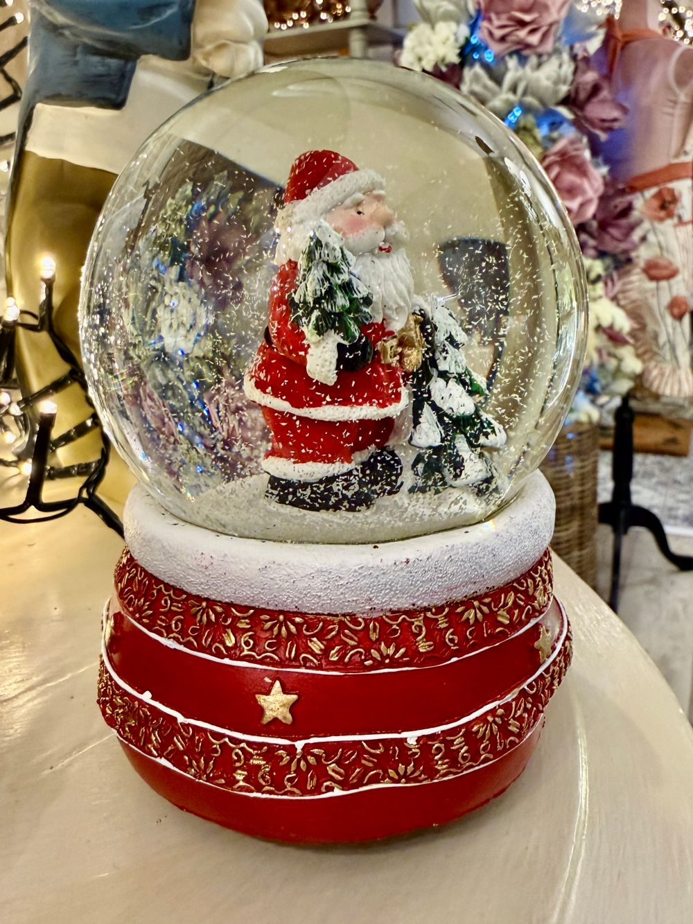 Boule à neige Père Noël musical rouge et doré avec sapins enneigés, accessoire de décoration féérique et de charme pour Noël