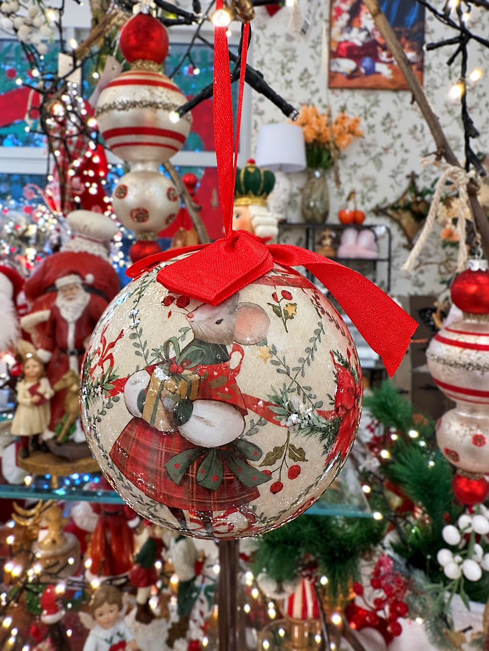 Boule de Noël Souris suspendue par son ruban rouge dans la boutique.