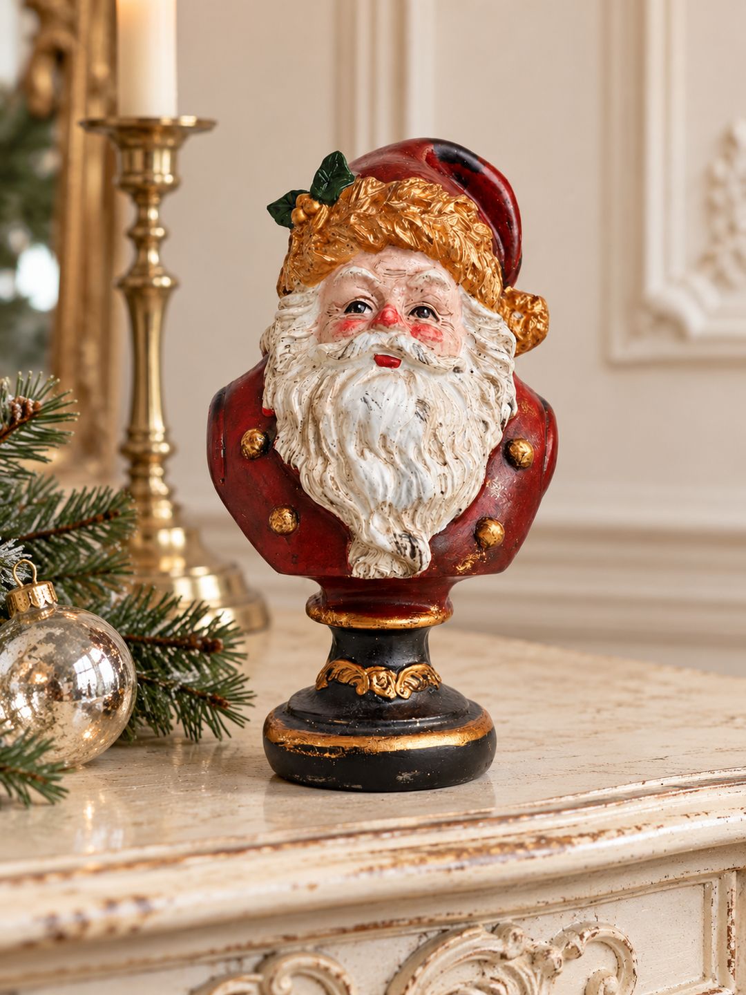Buste du Père Noël sur une console ivoire patinée, avec branches de sapin et boule de Noël.