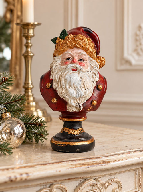 Buste du Père Noël sur une console ivoire patinée, avec branches de sapin et boule de Noël.