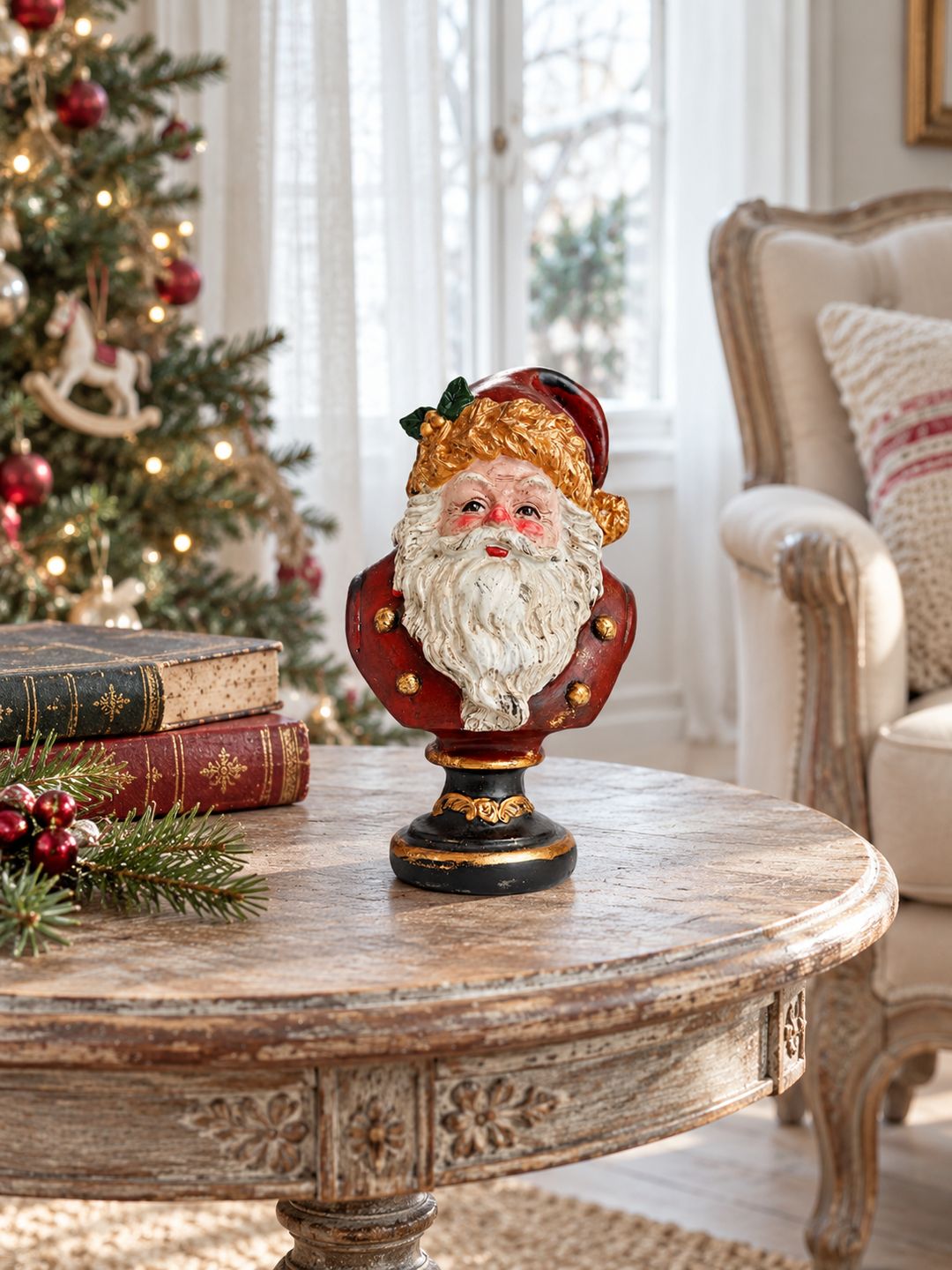 Buste du Père Noël sur un guéridon ancien, avec livres, sapin décoré et fauteuil écru en arrière-plan.