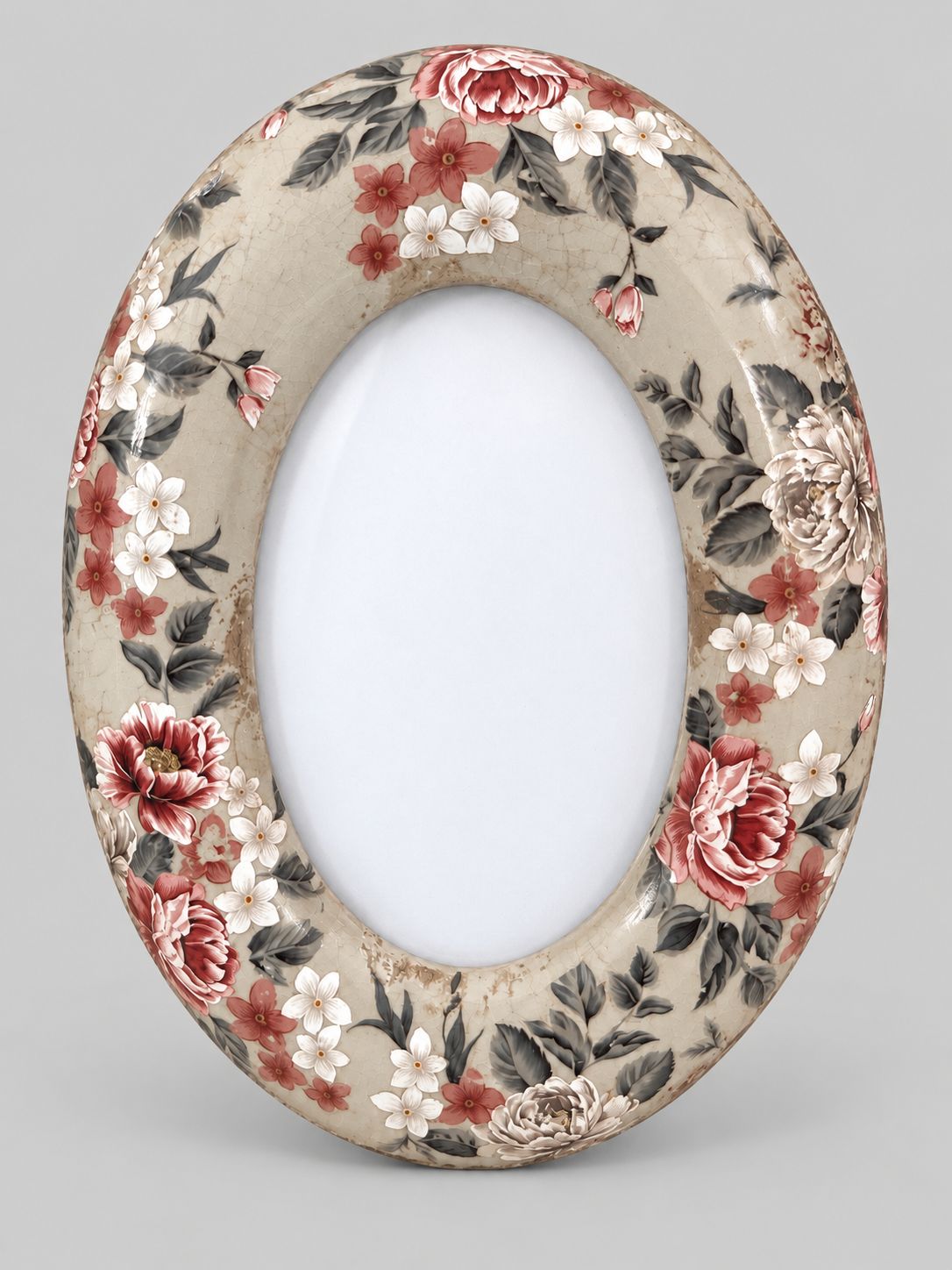 Cadre photo ovale en céramique beige craquelée, à motifs floraux rouges et blancs, sur fond gris clair.