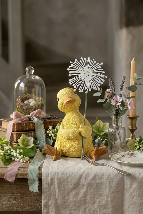 Caneton décoratif jaune tenant une fleur blanche, figurine au charme printanier dans un univers romantique, shabby chic et poétique, idéale pour une décoration de charme douce et féérique
