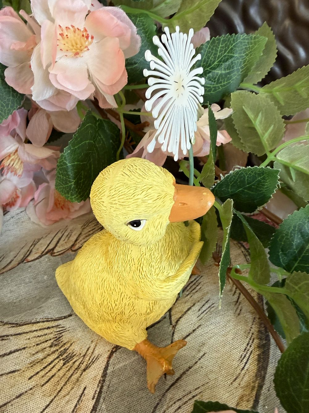 Caneton décoratif jaune tenant une fleur blanche, figurine au charme printanier dans un univers romantique, shabby chic et poétique, idéale pour une décoration de charme douce et féérique