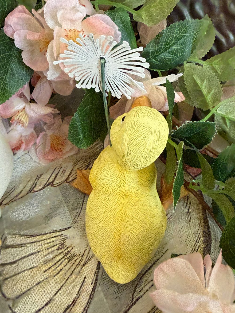 Caneton décoratif jaune tenant une fleur blanche, figurine au charme printanier dans un univers romantique, shabby chic et poétique, idéale pour une décoration de charme douce et féérique