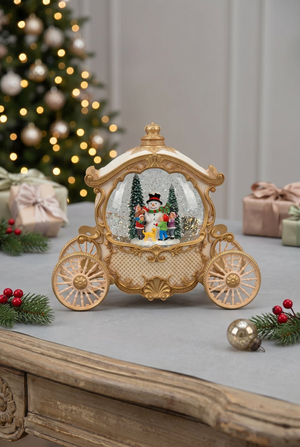 Carrosse décoratif lumineux et musical style conte de fées, boule à neige de Noël avec scène hivernale, bonhomme de neige et enfants sous les flocons, décoration féérique ivoire et or