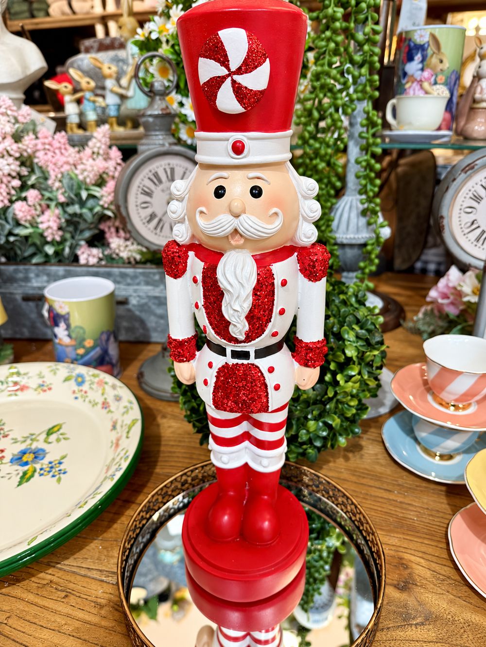 Casse-Noisette Candy Pailleté vu de face en boutique, avec sa tenue rouge et blanche et son chapeau à motif de bonbon.
