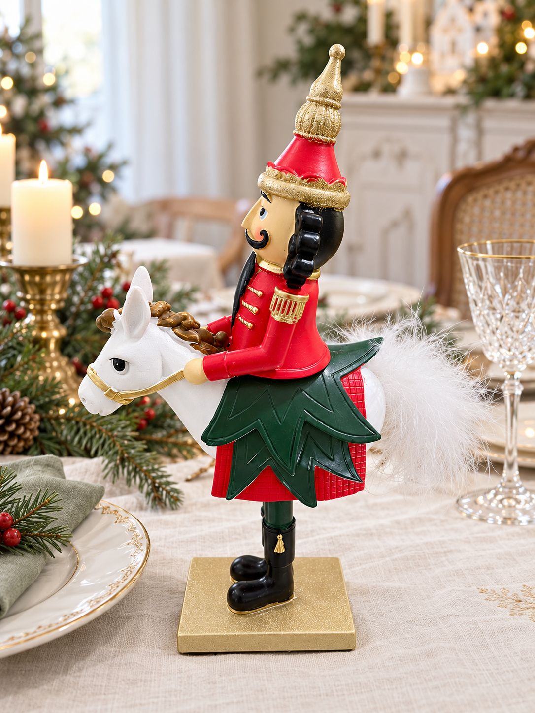 Casse-Noisette Cavalier Royal vu de profil sur une table de fête, avec vaisselle dorée et serviette vert sauge.