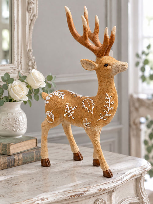 Cerf décoratif Le Prince des Forêts sur une console blanc cassé patinée, accompagné de livres anciens et de roses blanches.