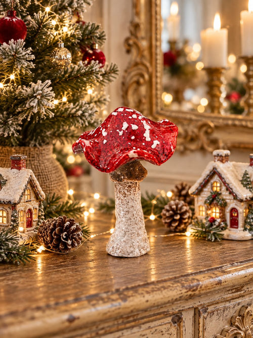Champignon décoratif rouge et blanc dans une composition de Noël féérique sur une console