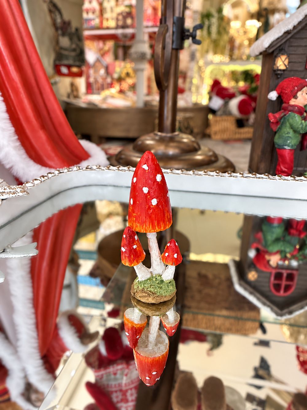 Petit champignon décoratif miniature rouge à pois blancs sur pied clair et base verte, pour décor féérique, village de Noël ou scène de sous-bois.