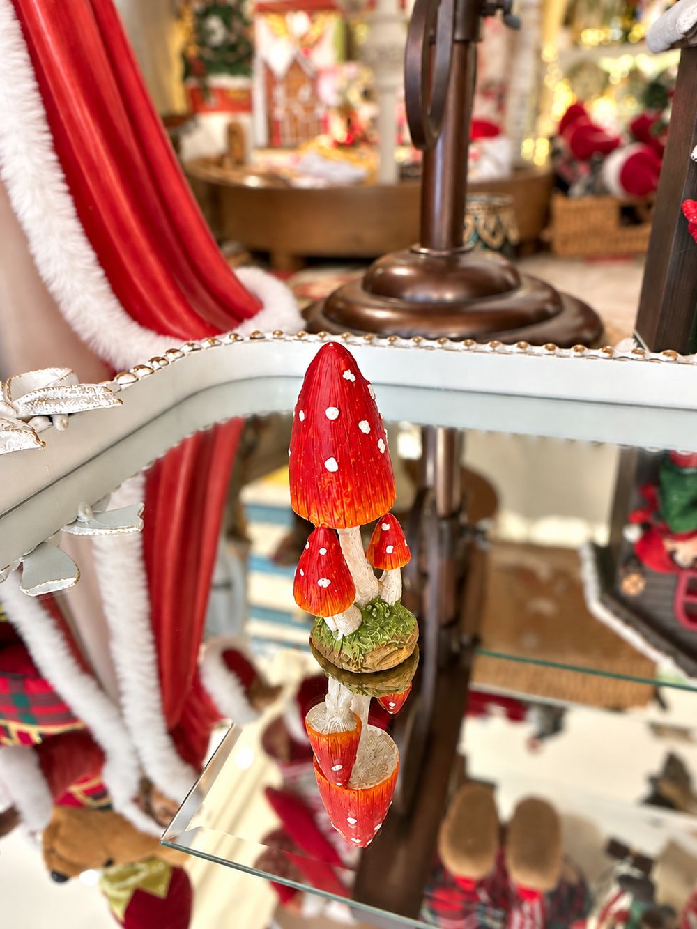 Petit champignon décoratif miniature rouge à pois blancs sur pied clair et base verte, pour décor féérique, village de Noël ou scène de sous-bois.