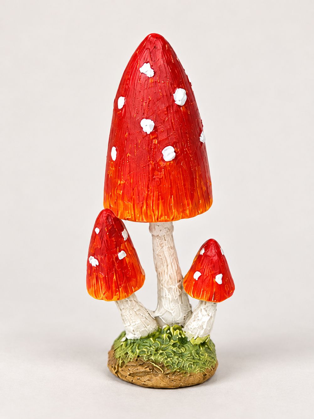 Petit champignon décoratif miniature rouge à pois blancs sur pied clair et base verte, pour décor féérique, village de Noël ou scène de sous-bois.