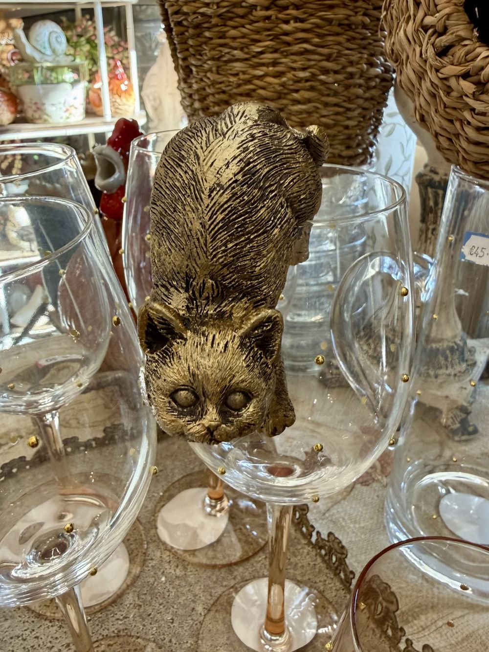 Chat grimpeur décoratif or vieilli accroché à un rebord dans une ambiance de décoration shabby chic romantique et poétique