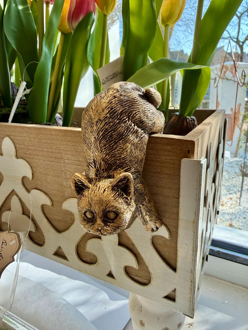 Chat grimpeur décoratif or vieilli accroché à un rebord dans une ambiance de décoration shabby chic romantique et poétique