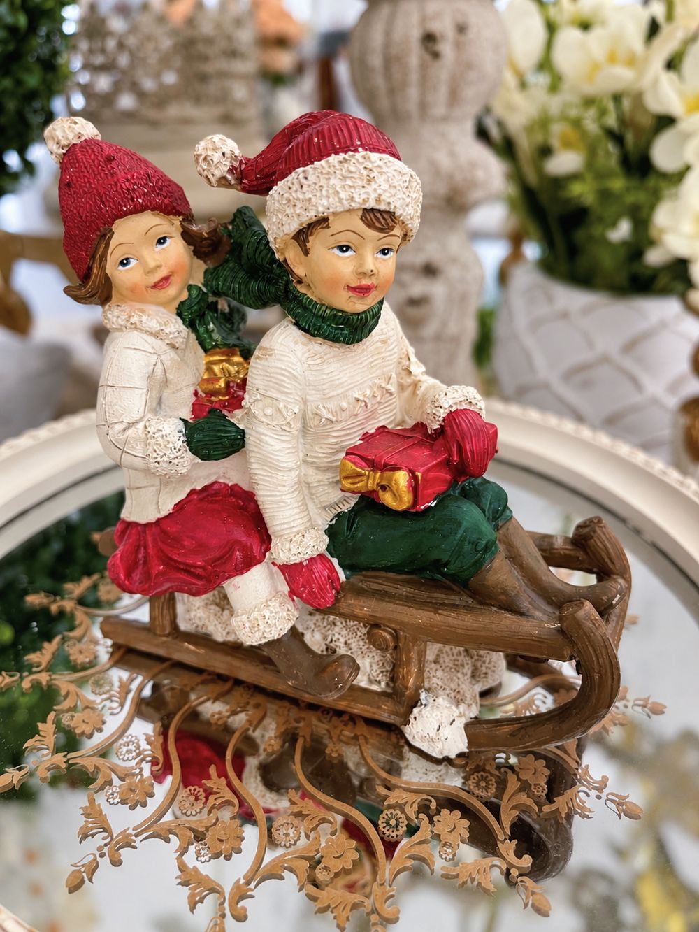 Figurine Chérubins sur une luge, vue de face sur un plateau miroir.
