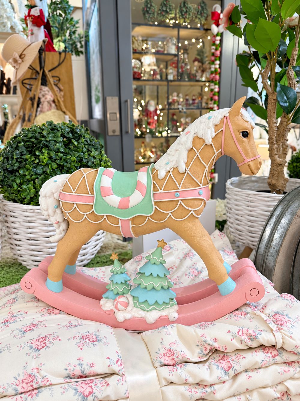 Grand cheval à bascule décoratif aux tons rose pastel, vert menthe, blanc et caramel, dans un style féérique et gourmand pour une décoration de Noël poétique.
