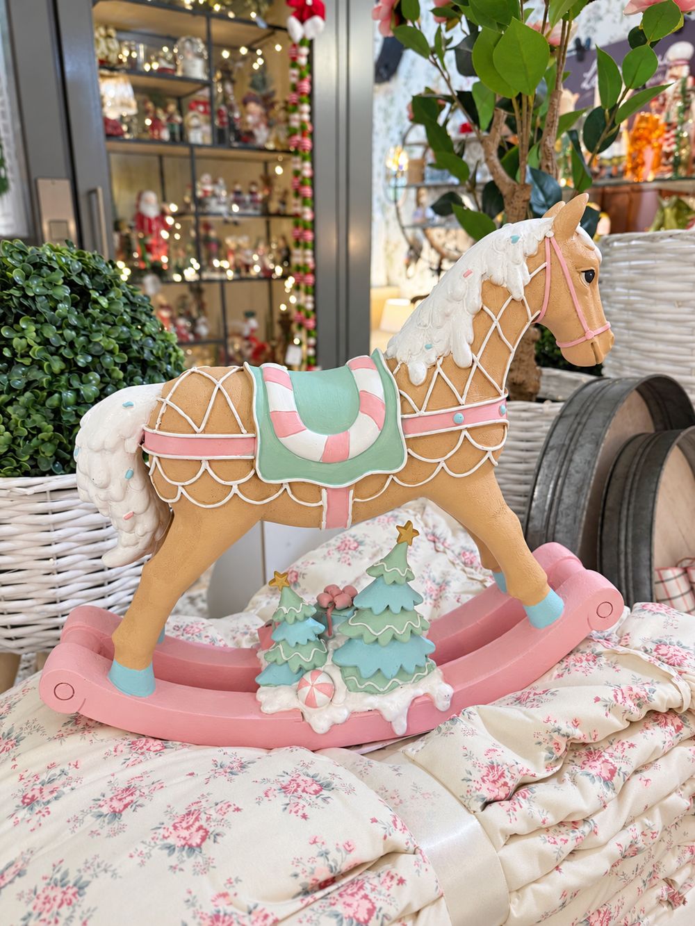 Grand cheval à bascule décoratif aux tons rose pastel, vert menthe, blanc et caramel, dans un style féérique et gourmand pour une décoration de Noël poétique.
