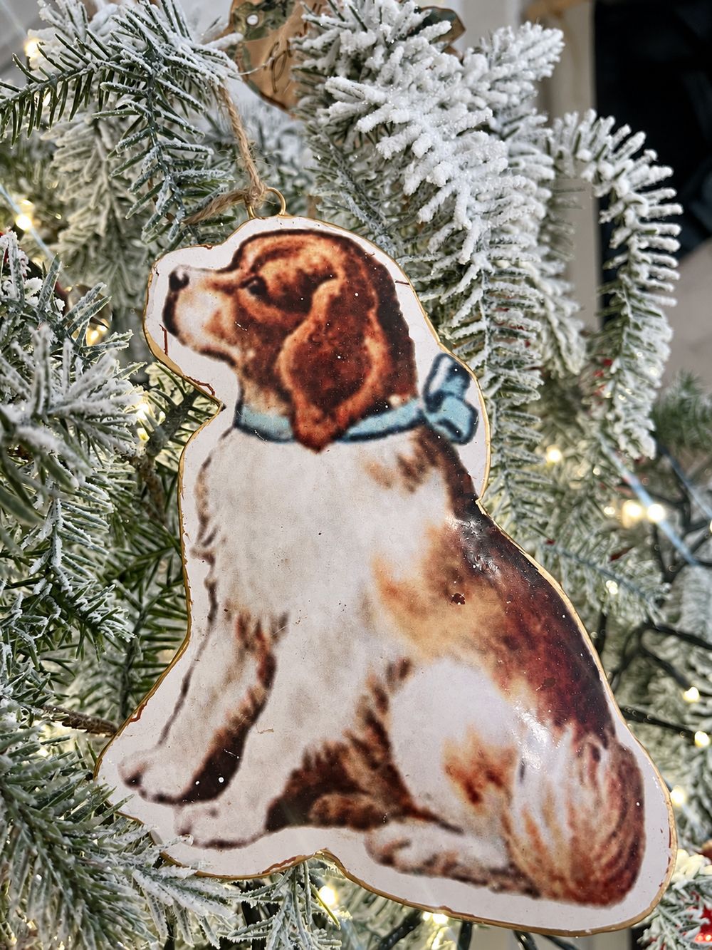 Suspension chien victorien au nœud bleu, vue de face dans un sapin givré.